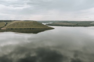 Sakin, sakin bir su. Büyük bir nehrin kıyıları, panoramik manzara. Bakota, Dinyester Nehri, Ukrayna. Yüksek bankalar, yeşil tepeler. Doğu Avrupa 'da yaz günü.
