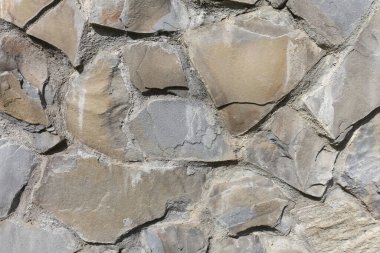 Stone wall background. Grunge close up texture. Bumpy stone surface, a fragment of an old wall. Detailed background.