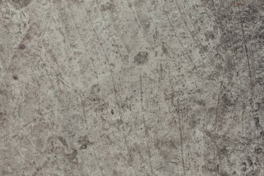 A concrete wall texture with cracks and scratches. Abstract background, old cement wall. Easily add depth and organic texture to your designs. Minimal urban photo in warm gray palette.