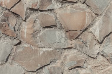 Grunge dokuyu kapat. Eski bir duvarın parçası. Sarsıntılı taş yüzey. Taş duvar arka planı. Ayrıntılı bej taşı arkaplanı.