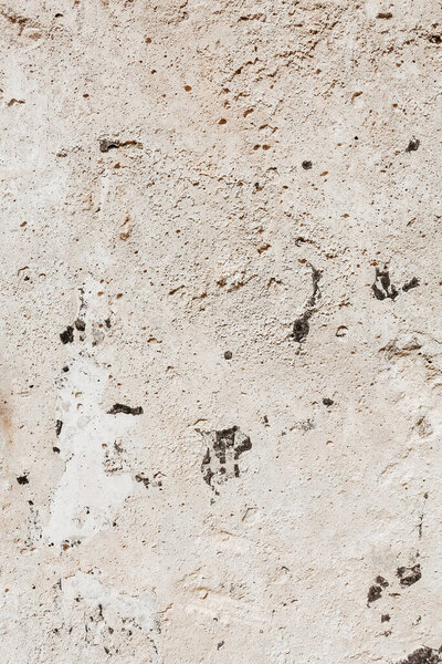 Concrete stone wall background. A fragment of an old wall, stone surface. Grunge texture close up. Detailed background in calm beige colors.