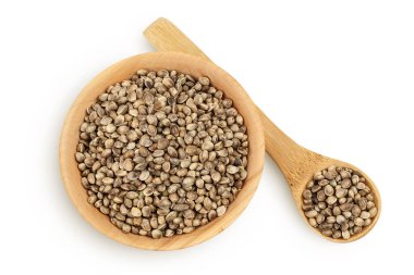 Ahşap kasedeki kenevir tohumları beyaz arka planda izole edilmiş, geniş bir alana yayılmış. Üst Manzara. Düz yatıyordu.