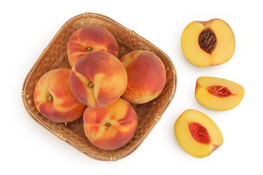 Olgun şeftali meyvesi, yarısı hasır sepetin içinde beyaz arka planda izole edilmiş, geniş bir alana yayılmış. Üst Manzara. Düz yatıyordu.