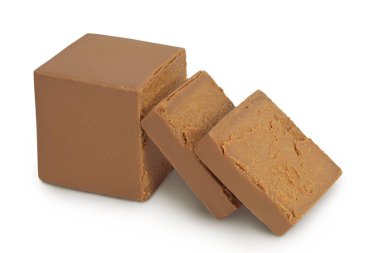 Esmer peynir. Norveç brunost 'u tam derinlikteki beyaz arka planda izole edildi.