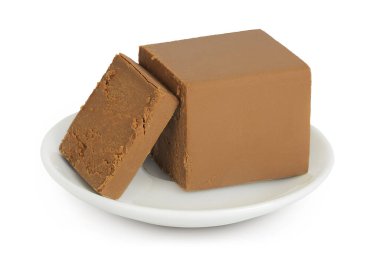 Esmer peynir. Beyaz arka planda tam derinlikte izole edilmiş seramik bir kasede Norveç kahvaltısı..