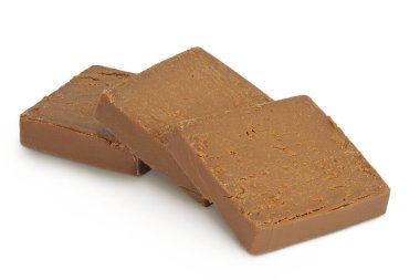 Esmer peynir. Norveç brunost 'u tam derinlikteki beyaz arka planda izole edildi.