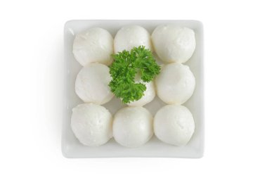 Beyaz arka planda izole edilmiş seramik kasede maydanozlu mini mozzarella topları. Üst Manzara. Düz yatıyordu