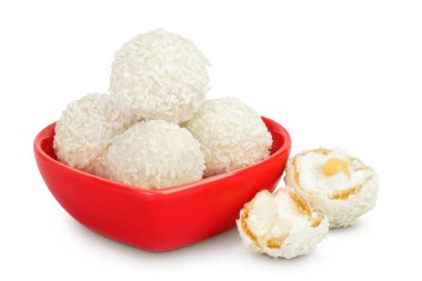 Beyaz arka planda izole edilmiş seramik kasede hindistan cevizi gevreği ve fındıklı yuvarlak raffaello..