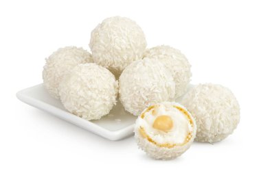 Beyaz arka planda izole edilmiş seramik kasede hindistan cevizi gevreği ve fındıklı yuvarlak raffaello..