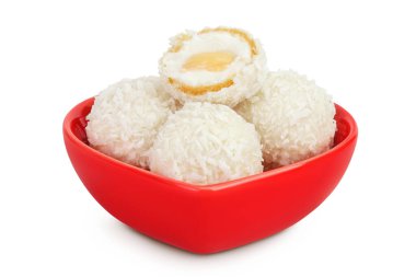 Beyaz arka planda izole edilmiş seramik kasede hindistan cevizi gevreği ve fındıklı yuvarlak raffaello..