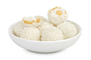 Beyaz arka planda izole edilmiş seramik kasede hindistan cevizi gevreği ve fındıklı yuvarlak raffaello..