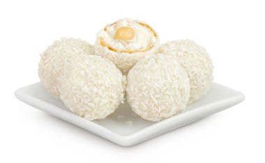 Beyaz arka planda izole edilmiş seramik kasede hindistan cevizi gevreği ve fındıklı yuvarlak raffaello..