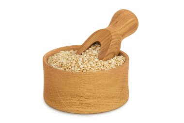 Tahta kasede susam tohumları ve beyaz arka planda izole edilmiş kepçeler..