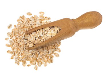 Ahşap kepçe içindeki yulaf gevrekleri beyaz arka planda izole edilmiş, geniş bir alana yayılmış. Üst Manzara. Düz yatıyordu.