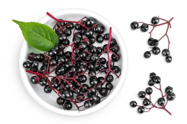 Olgun siyah mürver ya da beyaz arka planda izole edilmiş seramik kasede yeşil yapraklı yaşlı. Sambucus.