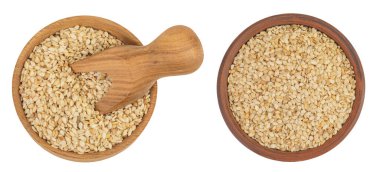 Tahta ve seramik kasede susam tohumları ve beyaz arka planda izole edilmiş kepçe. Üst Manzara. Düz yatıyordu.