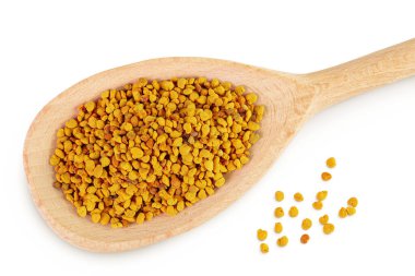 Beyaz arka planda izole edilmiş tahta kaşıktaki arı poleni taneleri. Üst Manzara. Düz yatıyordu.