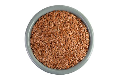 Beyaz arka planda izole edilmiş seramik kasede keten tohumu. Üst Manzara. Düz yatıyordu.