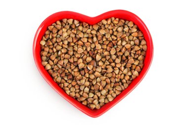 Beyaz arka planda izole edilmiş seramik kasede çiğ karabuğday. Üst Manzara. Düz yatıyordu.