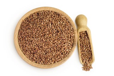 Beyaz arka planda izole edilmiş tahta kasede çiğ karabuğday. Üst Manzara. Düz yatıyordu.