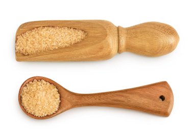 Tahta kepçedeki kahverengi şeker beyaz arka planda izole edilmiş. Üst Manzara. Düz yatıyordu.