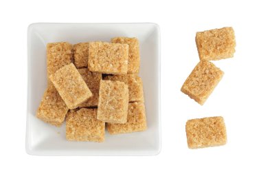 Beyaz arka planda izole edilmiş seramik kasede esmer şeker. Üst Manzara. Düz yatıyordu.