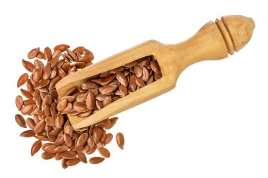 Tahta kepçe içindeki keten tohumu beyaz arka planda izole edilmiş. Üst Manzara. Düz yatıyordu.