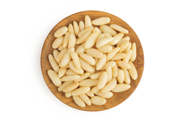 Shelled European pine nuts in wooden bowl isolated on white background with full depth of field. Top view. Flat lay.