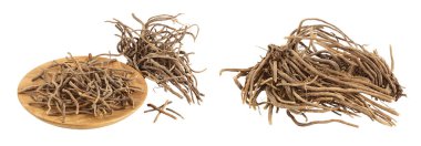 Dried Valerian root in wooden bowl isolated on white background. Valeriana officinalis with full depth of field