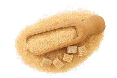 Beyaz arka planda izole edilmiş tahtadan bir kepçe dolusu kahverengi granüllü şeker ve şeker. Üst manzara, düz uzanma.