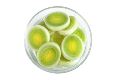 Beyaz arka planda izole edilmiş cam kasede kesilmiş pırasa sebzesi. Üst Manzara. Düz yatıyordu.