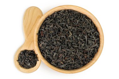 Tahta kasede kurumuş siyah çay yaprakları ve beyaz arka planda izole edilmiş kaşık. Üst Manzara. Düz yatıyordu.