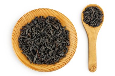 Tahta kasede kurumuş siyah çay yaprakları ve beyaz arka planda izole edilmiş kaşık. Üst Manzara. Düz yatıyordu.