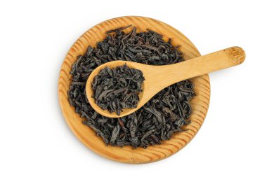 Tahta kasede kurumuş siyah çay yaprakları ve beyaz arka planda izole edilmiş kaşık. Üst Manzara. Düz yatıyordu.