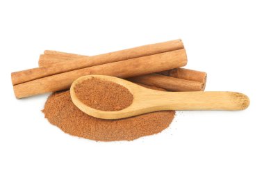 Tahta kaşıkta toz bulunan tarçın çubukları beyaz arka planda tam derinlikte izole edilmiş..