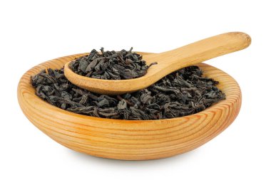 Tahta kasede kurumuş siyah çay yaprakları ve beyaz arka planda izole edilmiş kaşık..