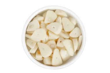 Beyaz arka planda izole edilmiş seramik kasede sarımsaklı karanfil dilimleri. Üst Manzara. Düz yatıyordu