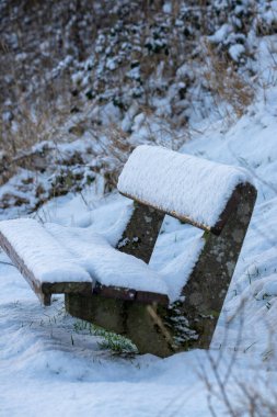 Kış mevsiminde kar kaplı park bankı