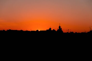 Şehir siluetinin basit arkaplanı binaların şekli çatı antenleri ve yüksek voltajlı cisimler, canlı turuncu gökyüzü manzarası
