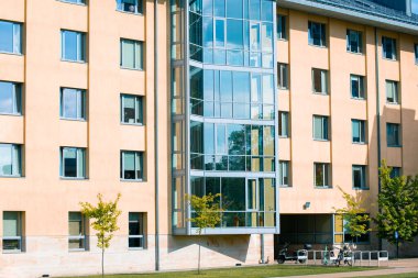 Modern üniversite kampüs binası dış cam pencereler ve yeşil çimenler güneşli yaz zamanı