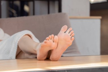 Çıplak ayakla kadın uzvu, temiz parmaklar ve ev içi rahat bir yer.