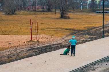 Köpeğinizle birlikte tanınmayan bayan kameraya geri dönüyorsunuz ve siyah av köpeğiniz açık havada ayaz çevre sahasının dışında fakir kenar mahallelerde kirli böcek ve mahvolmuş nesneyle geziyorsunuz.