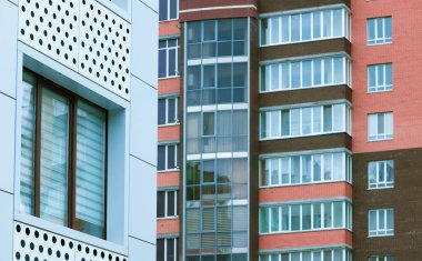 Apartman binası. Şehir manzarası. Duvarlar, şekiller ve pencereler ön planda ve arka planda.