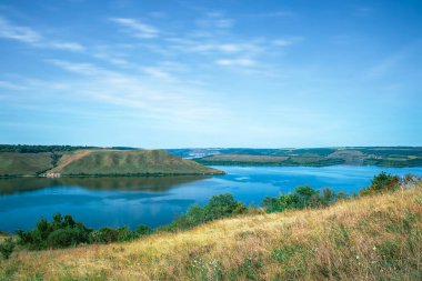 Cennet gibi yaz manzarası seyahat yeri fotoğrafçılık resim gibi kırsal tepeler mavi su nehri koyunun kıyı şeridi açık havada Haziran günü