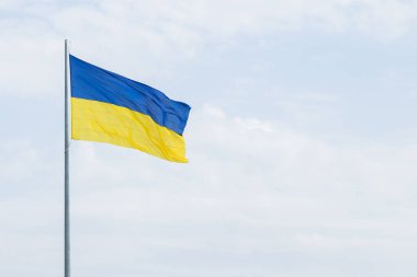 Bulutlu arka plan üzerinde Ukrayna bayrağı konsepti resmi sallamak metniniz için boş kopya alanı ile basit reklam deseni