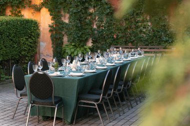 Masada boş çatal bıçak tabakları sundu ve cam köşk içti baharda eski bahçenin bahçesinde çiçek dikme ortamı