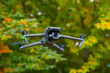 İHA 'lar hava fotoğrafçılığı ve video teknolojik cihaz sisteminde kanat pervaneleri ve gimbal kamera detaylarıyla uçuyor. Görüntüyü yakın çekimde bulanık doğal arkaplan alanı