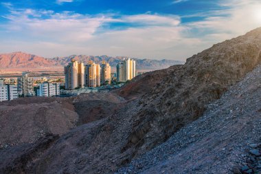 Kuru çöl şehri kıyısı güneşli kum taşları ön plandaki binalar Orta Doğu manzarası manzarası.