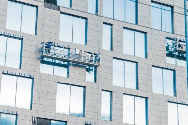 yüksek irtifa çalışması asma platformu dış gökdelen yan bina dış cephe gri duvar ve pencereler perspektif arka plan şehir manzarası konsepti
