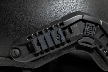 Askeri miğferin üzerindeki Picatinny rayı yüzey kaplamalı siyah kevlar malzeme arka planını kapat